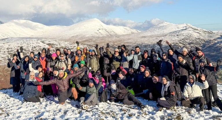 Muslim Hikers group at a snowy mountain, hands raised, celebrating — the Everest Base Camp trek