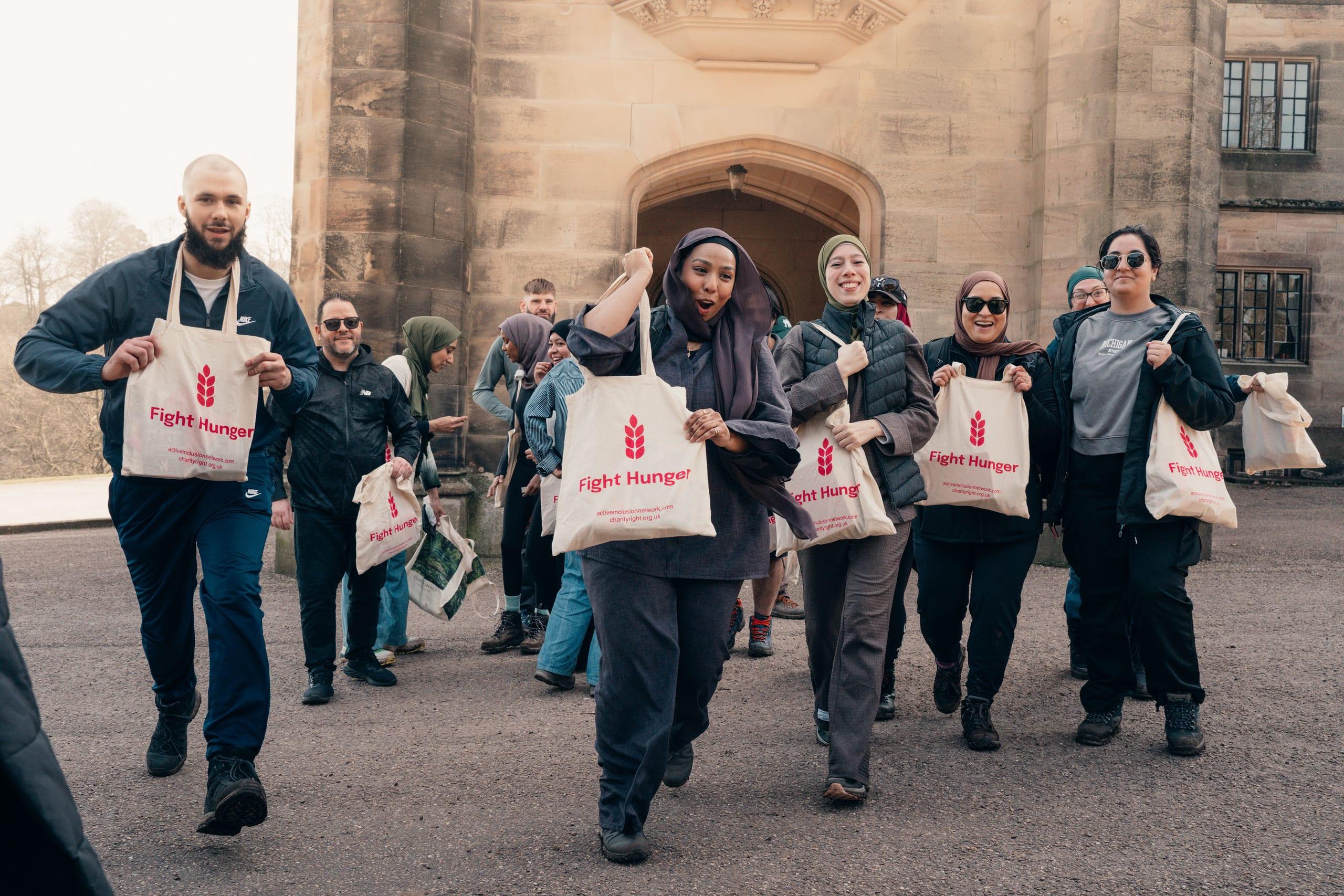 Community members walking together holding Fight Hunger Charity Right bags — the moment generosity is at its peak but pledges go uncaptured