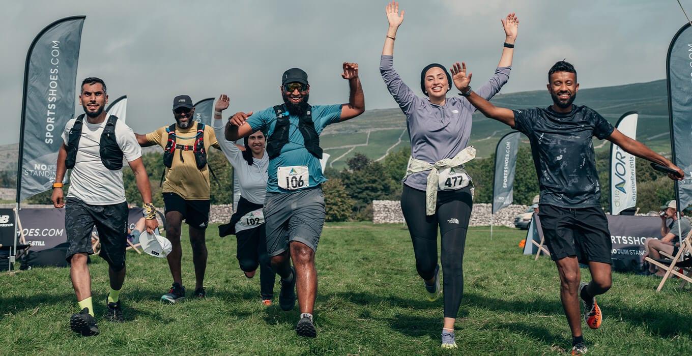 Muslim Runners crossing a finish line together with hands raised — friends and family promised to sponsor, then life got busy